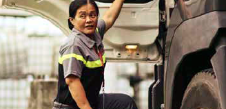 A woman truck driver at the side of a truck