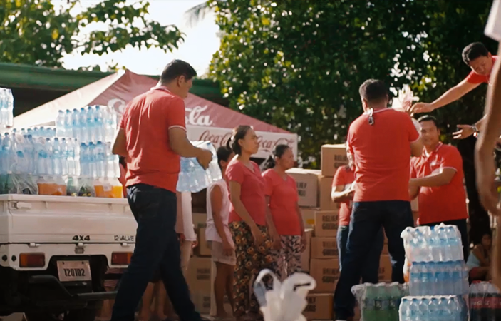 A group of people with red shirts unloading a truck