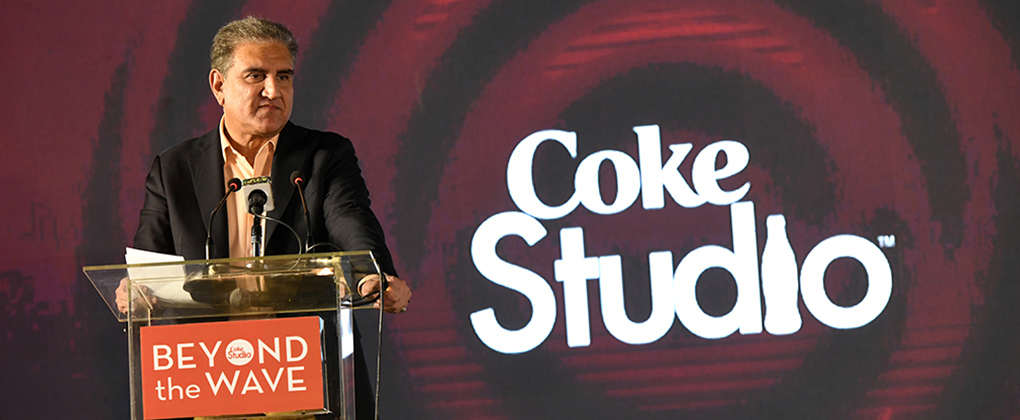 A man on a presentation panel with the Coke Studio logo in the background