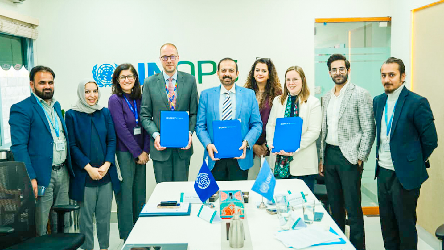 People standing in front of the UNOPS logo