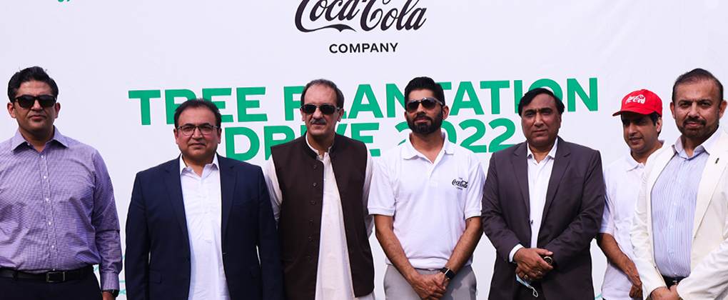 A group of men in front of the Tree Plantation Drive 2022 event banner