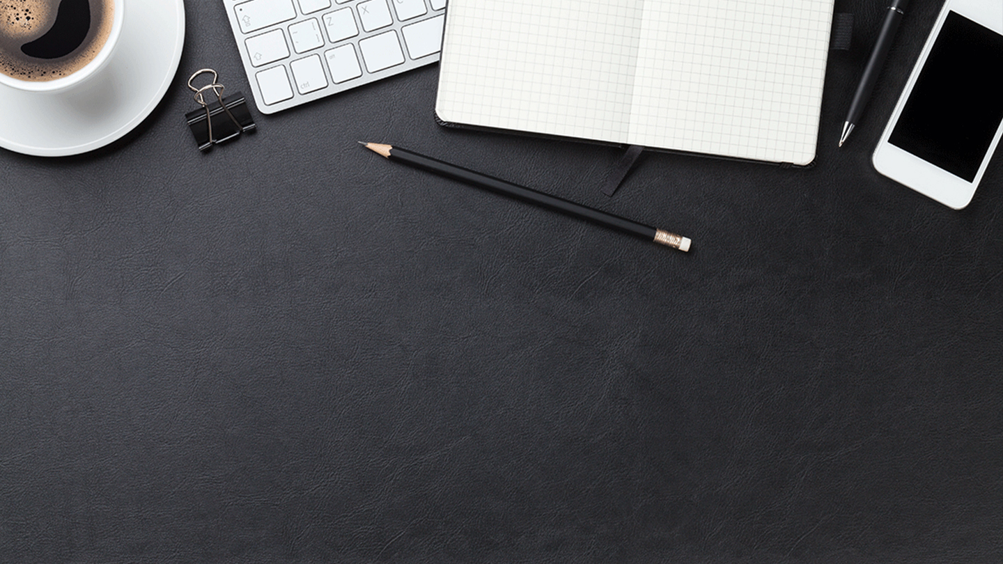 A top view of a desk with a cup of coffee, a pencil, a notebook and a cellphone