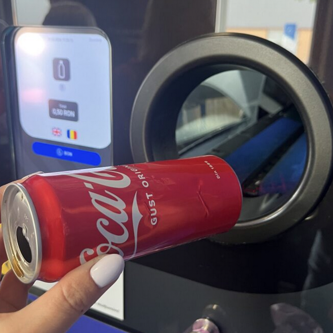 Puszka Coca-Cola wkładana do automatu do recyklingu.