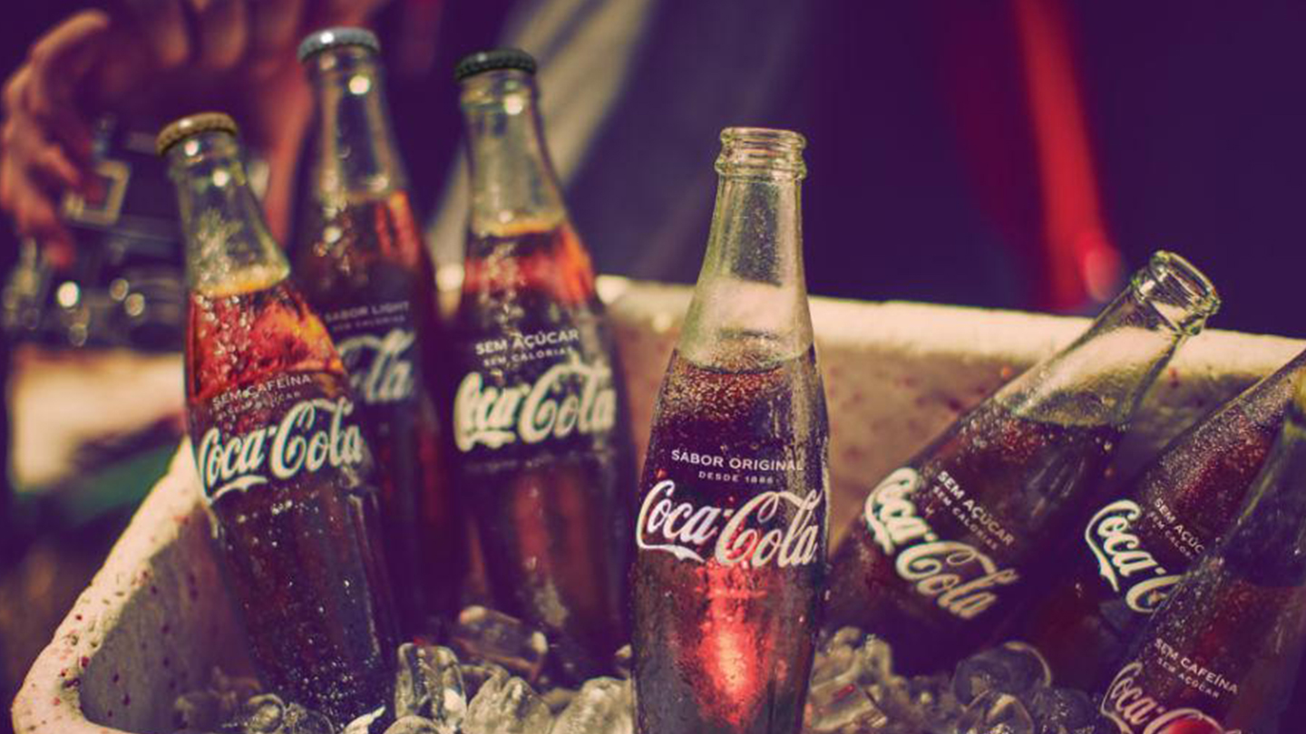 Um balde de gelo com várias garrafas de vidro de Coca-Cola