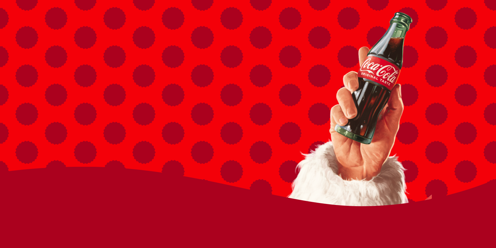 Mano de Papá Noel cogiendo una botella de Coca-Cola