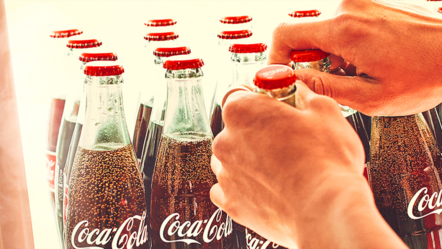 Docenas de botellas de vidrio de Coca-Cola en caja.