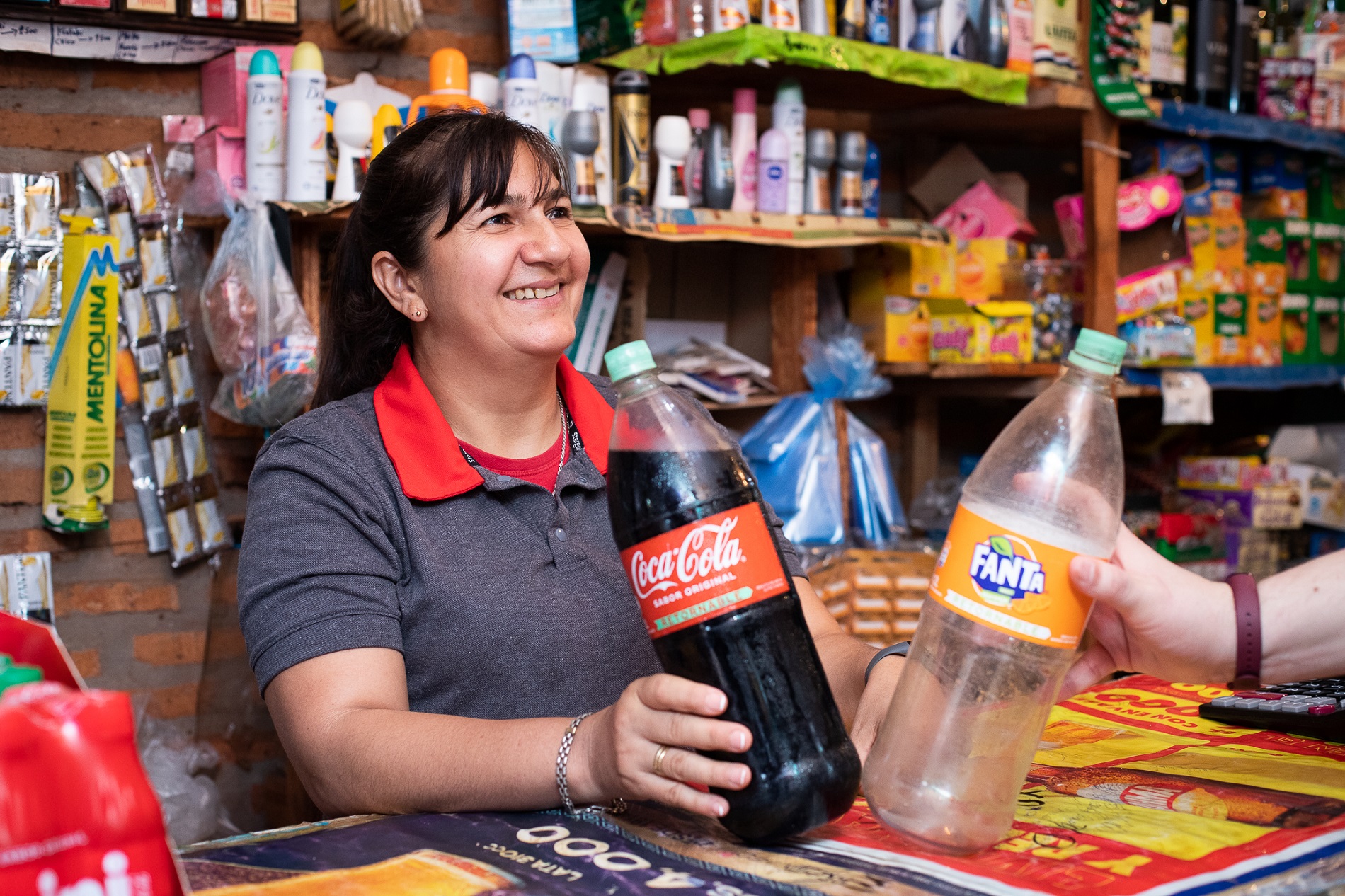 Mujer en una tienda con Coca-Cola y Fanta vacía