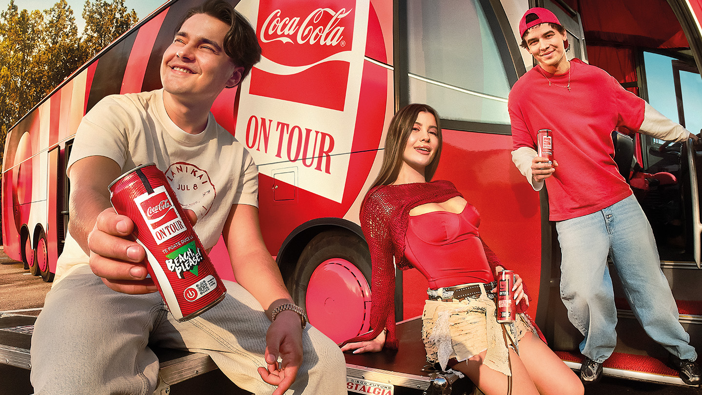 Selly intinde o doza personalizata de Coca-Cola, in fata unui autocar colantat cu emblema Coke on Tour