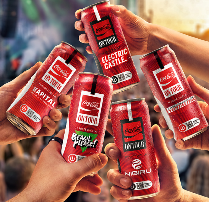 Mâini care țin cutii de Coca-Cola la un festival