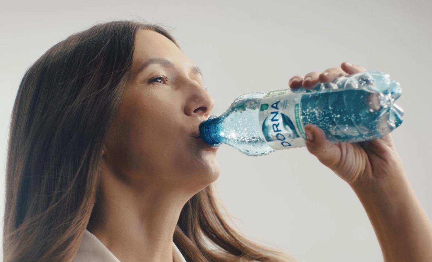 O femeie care bea o sticlă de Dorna