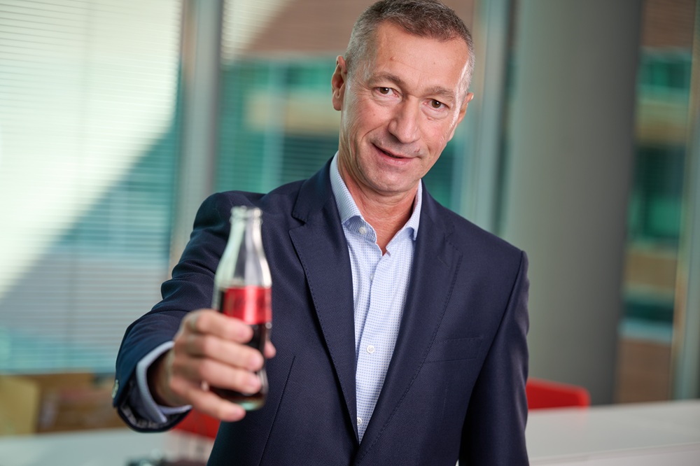 o imagine cu un bărbat care ține o sticlă de Coca-Cola