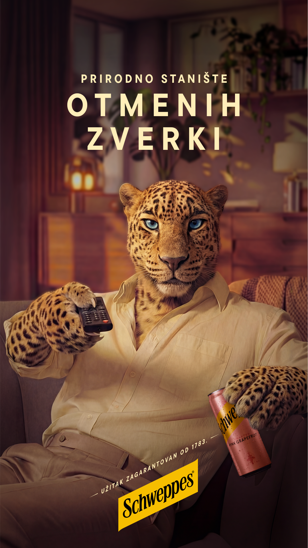 Leopard je sedeo na sofi okrenut ka kameri, držeći konzervu Schweppes Pink Grapefruit u jednoj ruci i daljinski upravljač za televizor u drugoj ruci, usmeravajući daljinski upravljač ka kameri.