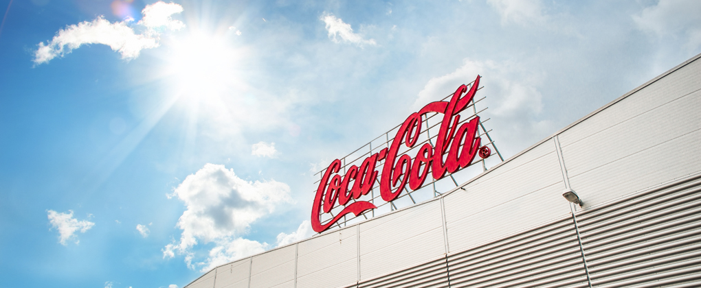 Coca-Cola-skylten på Sveriges produktionsanläggning i Jordbro och en blå himmel