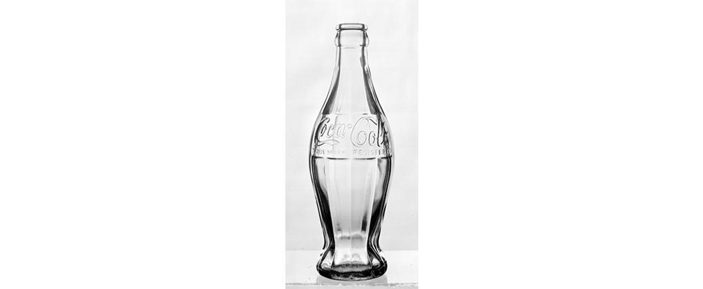 Den klassiska Coca-Cola-flaskan i glas från 1915