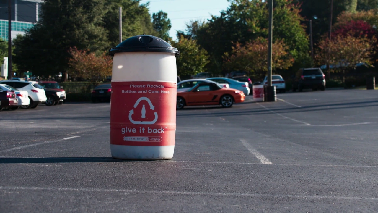 A recyclable trash bin for bottles and cans made by Coca-Cola