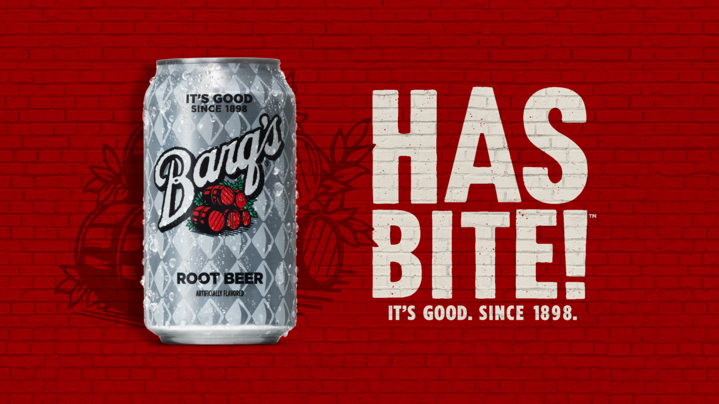 A Barq's can in front of a red-colored brick wall background with the phrase 'Has bite! It's good, since 1898." displayed beside it