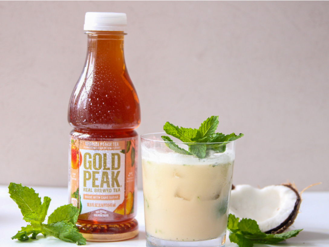 a bottle of gold peak tea next to a mixed drink