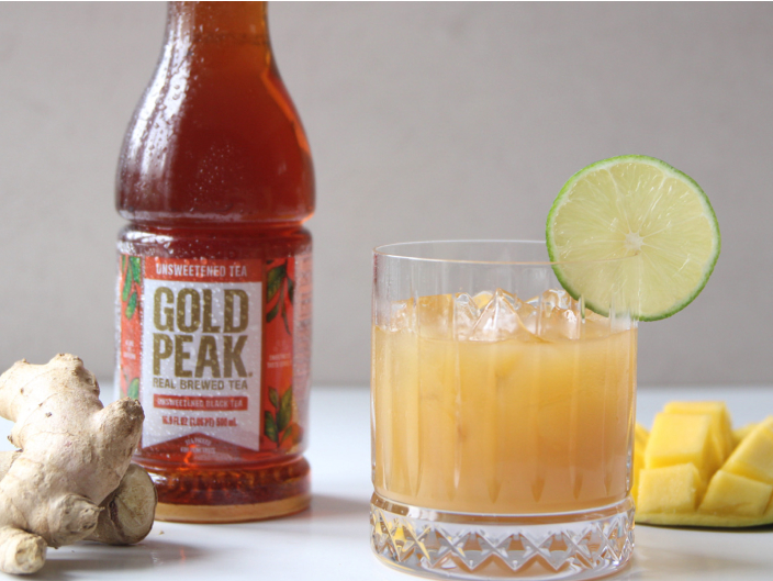 gold peak bottle next to orange mocktail