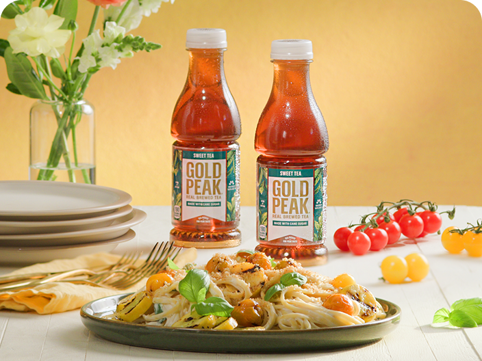 Gold peak tea drinks sitting on a table with food