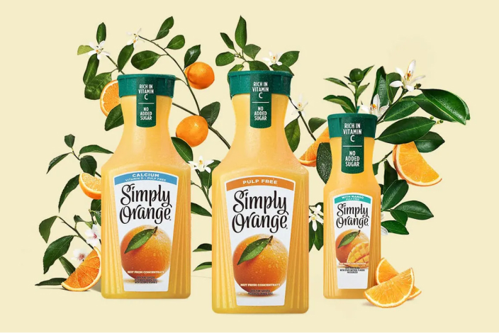 Three containers of different Simply Orange options with fruit and greenery in the background
