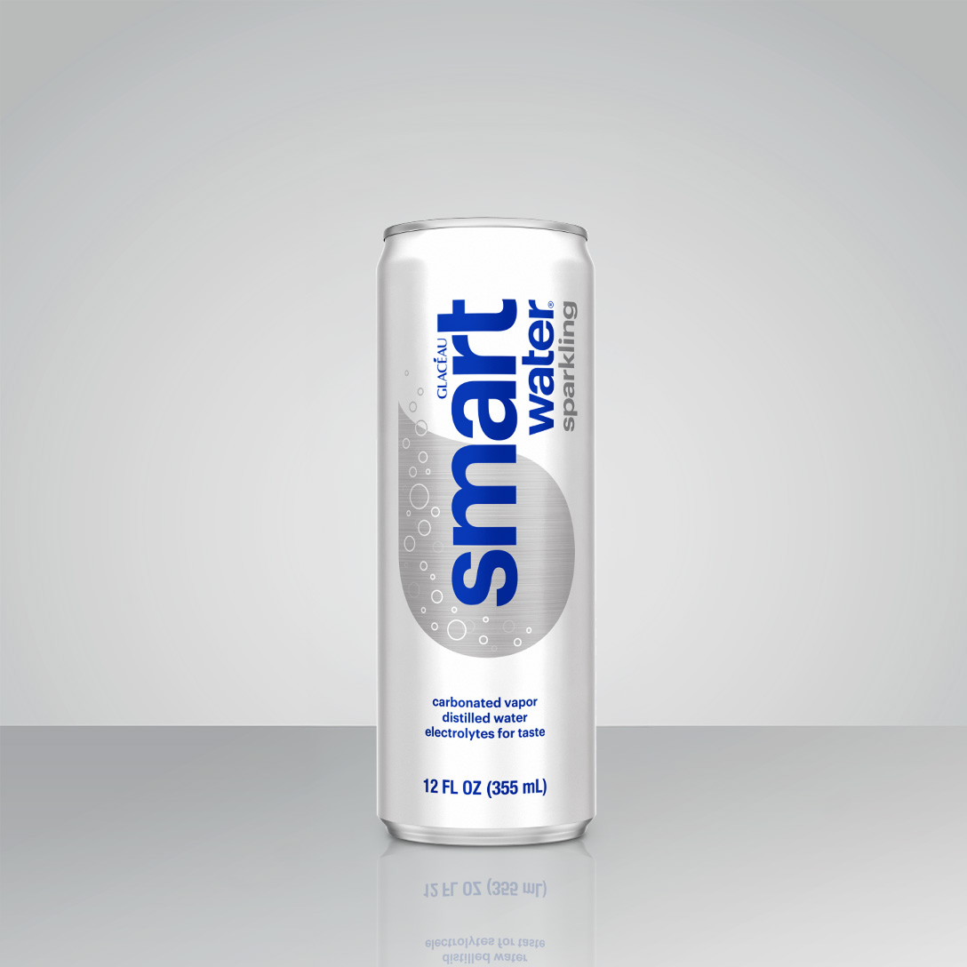 A silver Glacéau Smartwater Sparkling can labeled "carbonated vapor, distilled water, electrolytes for taste, 12 FL OZ (355 mL)," standing on a reflective surface against a gray background.