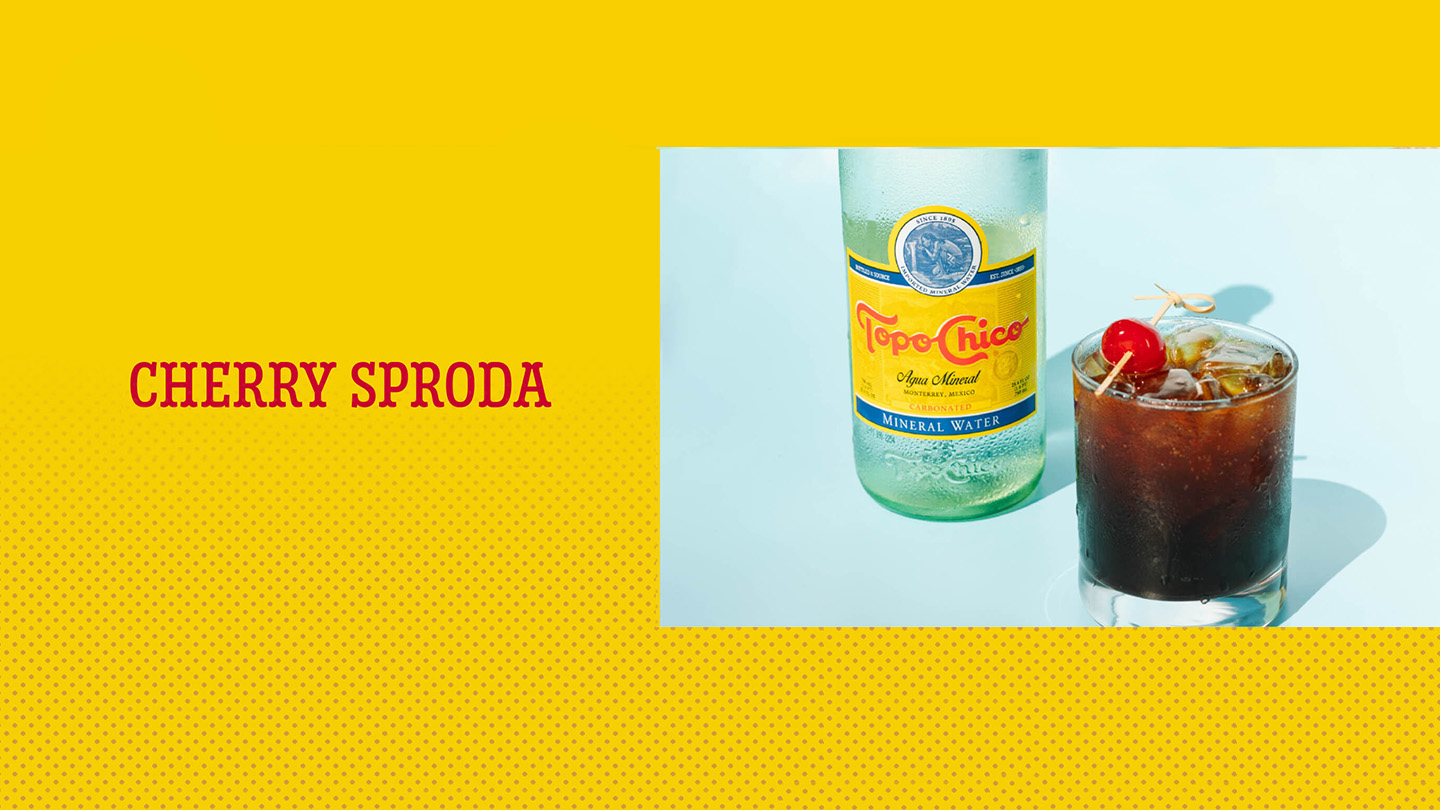 A cherry sproda glass next to a Topo-Chico bottle