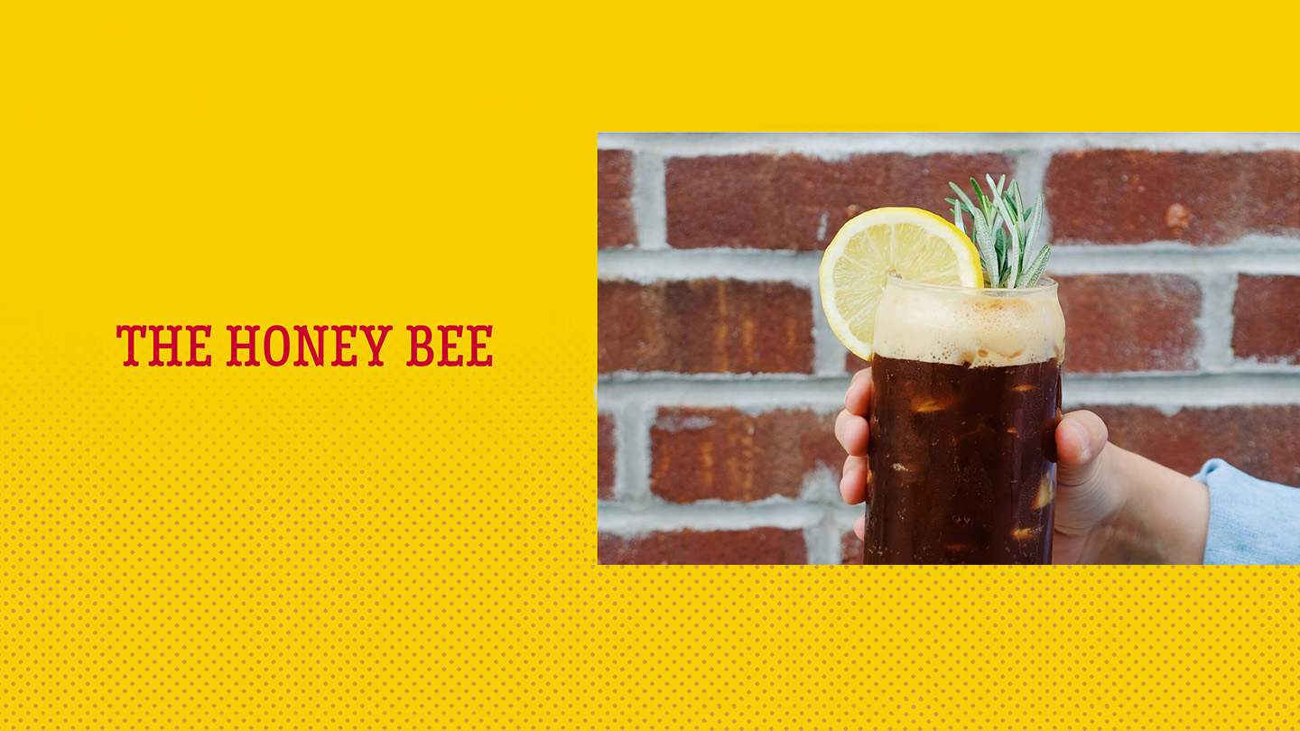 A person holding a glass with the honey bee drink
