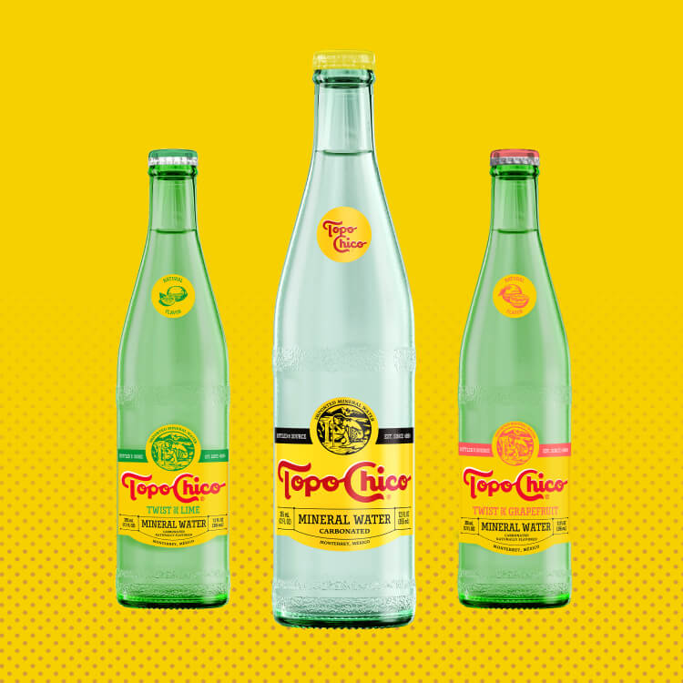 Four Topo Chico bottles in a yellow background