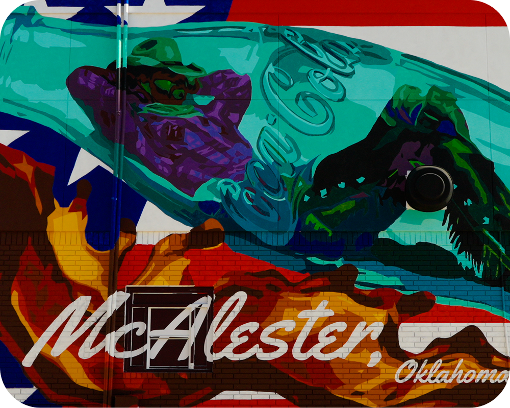 Close-up of the painted Coca-Cola bottle and cowboy in the America 250 mural in McAlester, Oklahoma.
