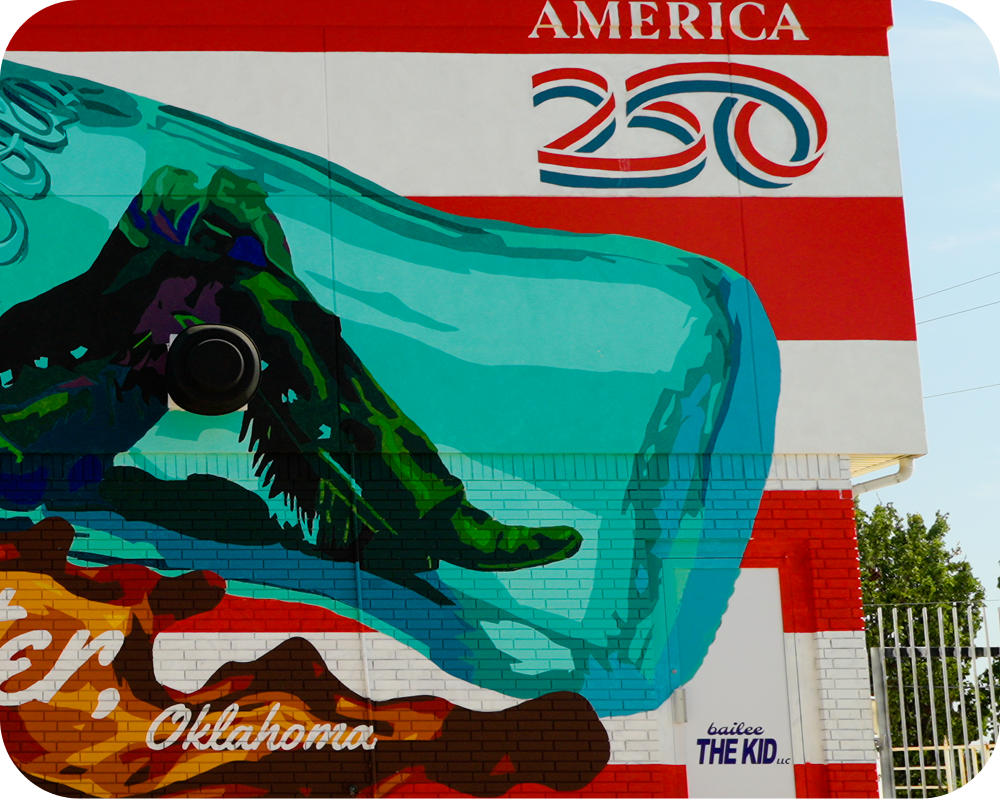 Right-side detail of the Coca-Cola mural showing the America 250 logo and artist signature by bailee THE KID.
