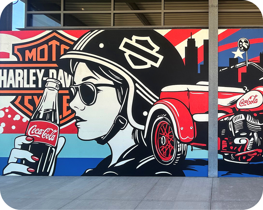 Close-up of the Greg Gossel mural highlighting a retro woman drinking a Coke while sitting on a Harley-Davidson.