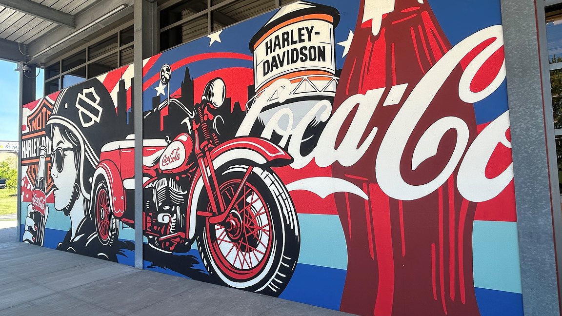Angled view of the Paint the Nation Coca-Cola and Harley-Davidson mural highlighting the vintage motorcycle and iconic glass bottle