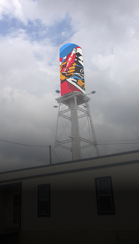 Tower mural showing Coca-Cola bottle artwork above rooftops and cloudy sky