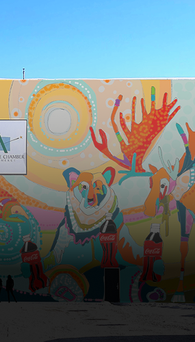 mural of colorful bear and deer sharing Coca-Cola bottles under bright swirling sun