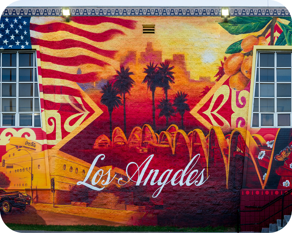 Vibrant Los Angeles America 250 mural featuring palm trees, a Coca-Cola truck, and an American flag.