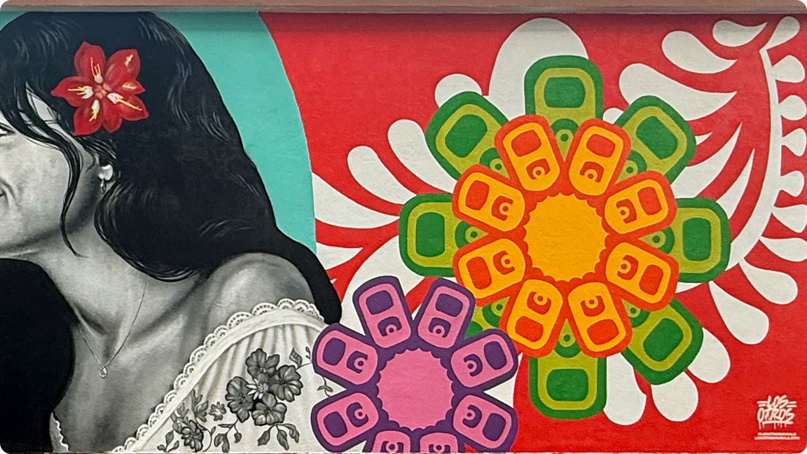 Detail from the Coca-Cola 'Los Otros' mural, showing a woman with a flower in her hair next to vibrant graphic florals.