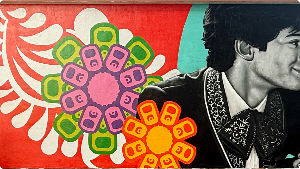 Detail from the Coca-Cola 'Los Otros' mural, focusing on the man in a charro suit and the vibrant graphic florals to his left.