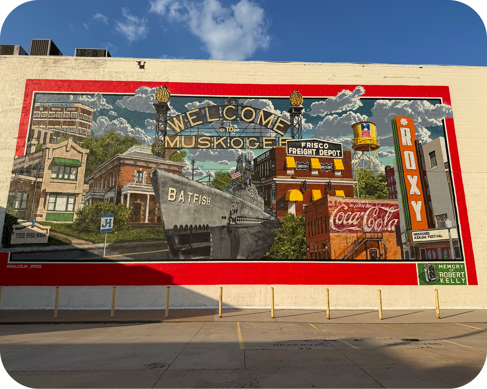 Full view of the Muskogee America 250 mural highlighting local landmarks like the Roxy theater and a Coca-Cola ad.