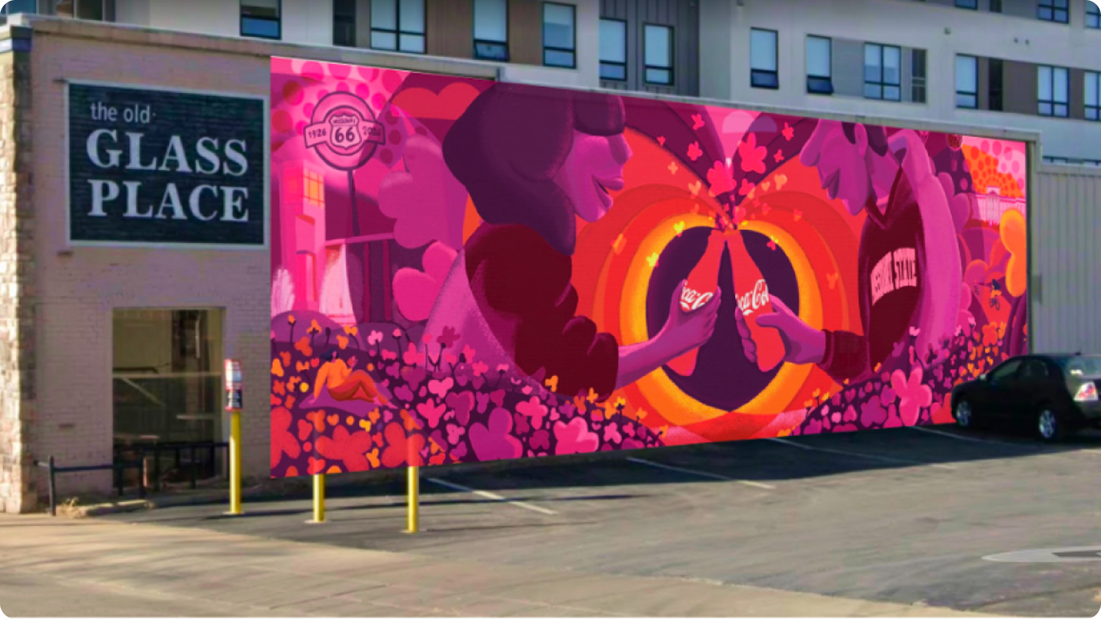 Completed Meg Wagler Coca-Cola mural on The Old Glass Place wall, with hearts and flowers above the parking lot.