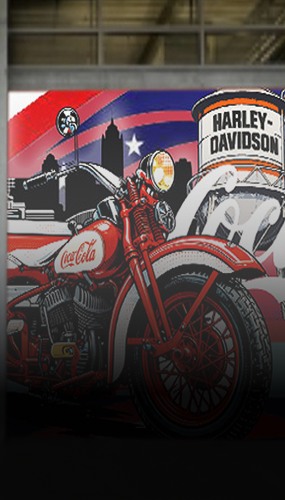 mural featuring vintage Coca-Cola motorcycle and Harley-Davidson sign against city skyline