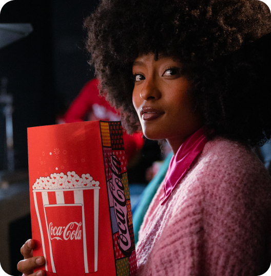 Guest holding Coca-Cola branded popcorn bucket during Cinemark film shoot