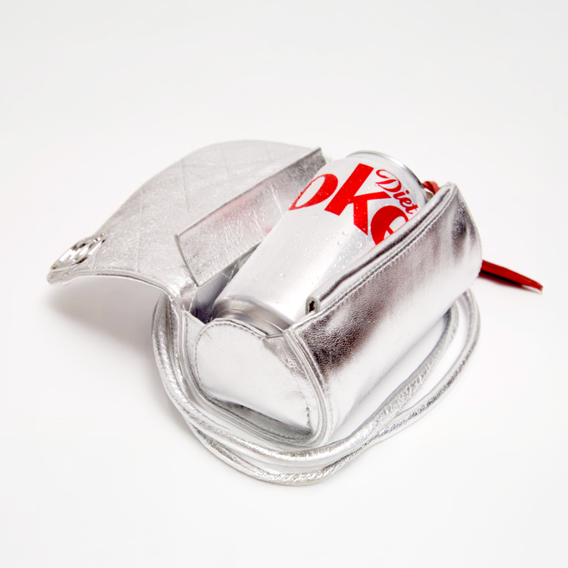 Open silver Diet Coke Canny Pack crossbody bag holding chilled Diet Coke can on white background