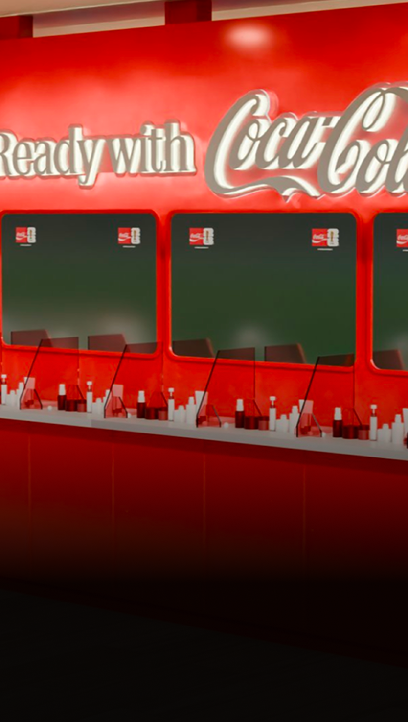 Render of Get Ready with Coca-Cola bar inside Fan Zone, with red sampling counter, taps and menu screens ready for guests.