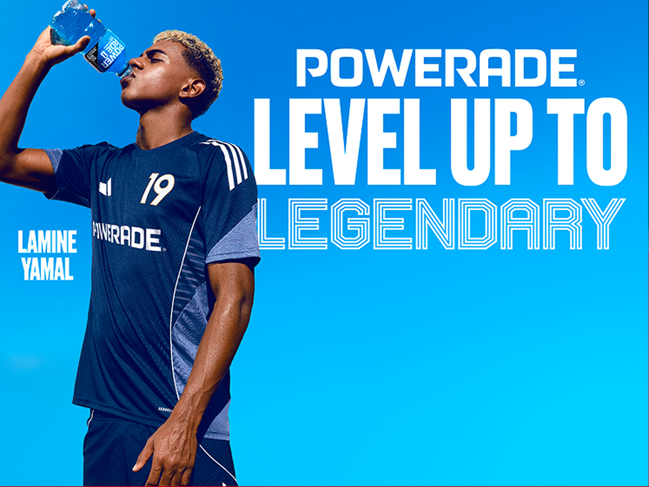 Soccer player in navy Powerade uniform drinking blue sports drink against bright blue background with bold “Level Up to Legendary” campaign line.