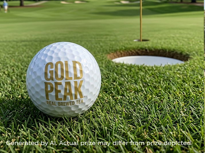 White golf ball with Gold Peak logo resting on green grass near the cup, showcased as a PGA Kroger sweepstakes prize.