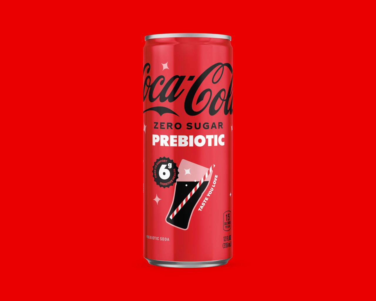 A red can of Coca-Cola Zero Sugar Prebiotic against a red background, featuring a "6g fiber to support digestive health" badge, a glass icon labeled "Taste You Love," and text noting 15 calories per can and 12 FL OZ (355 mL).