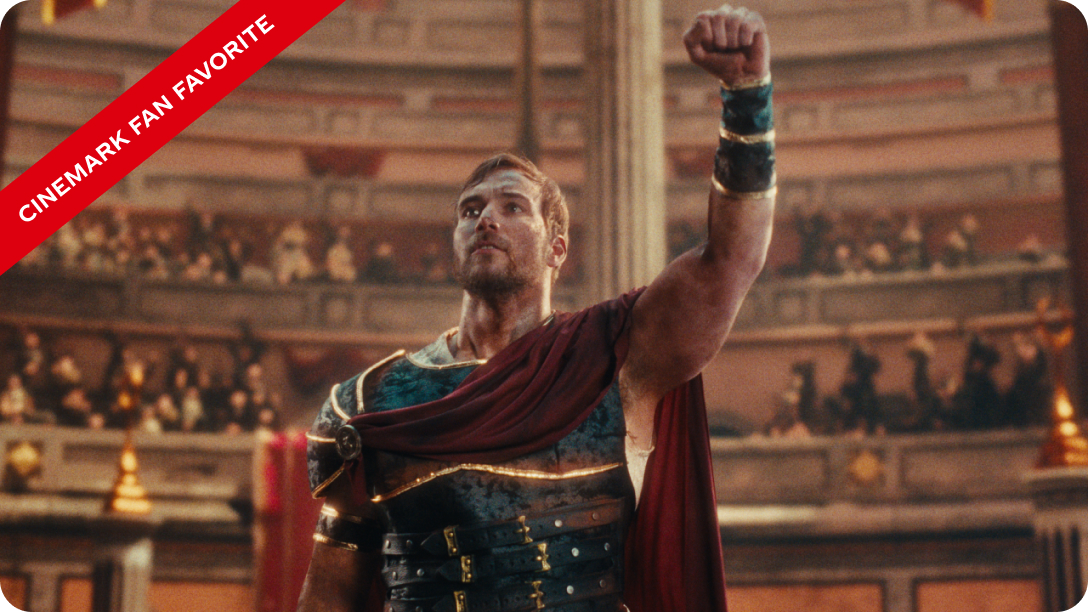 A gladiator in Roman armor raises his fist triumphantly in a colosseum arena, with a crowd visible in the background. A red "Cinemark Fan Favorite" banner appears in the top left corner.