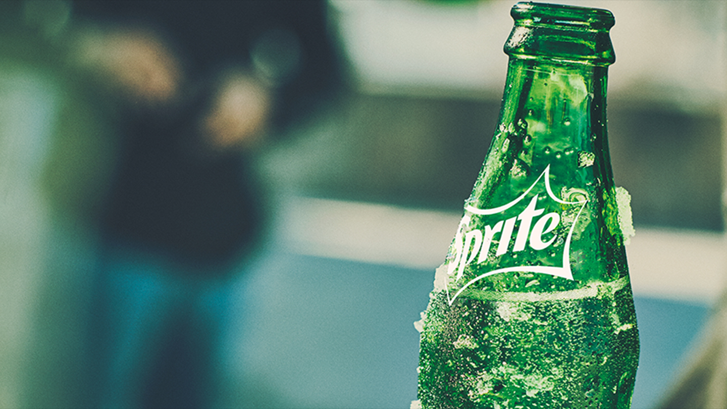 Botella de Sprite con persona de fondo