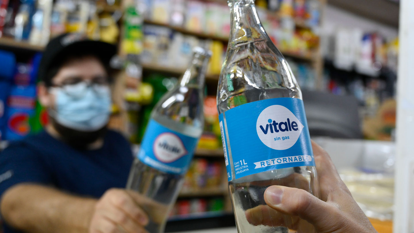 Manos sujetando dos botellas de cristal Vitale