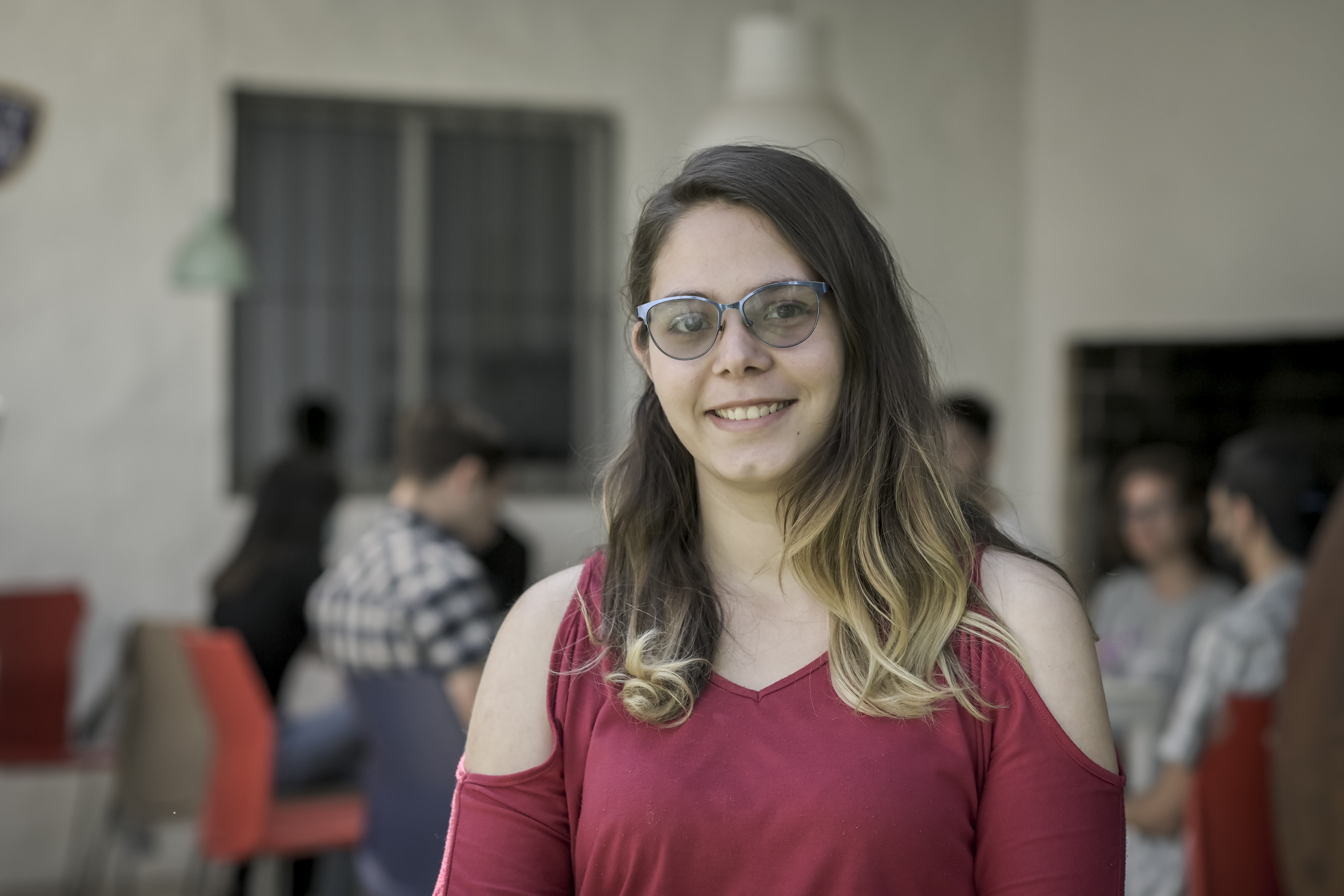 Chica joven sonriendo con personas de fondo